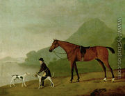 A saddled bay hunter with a groom and hounds, in a landscape - John Best